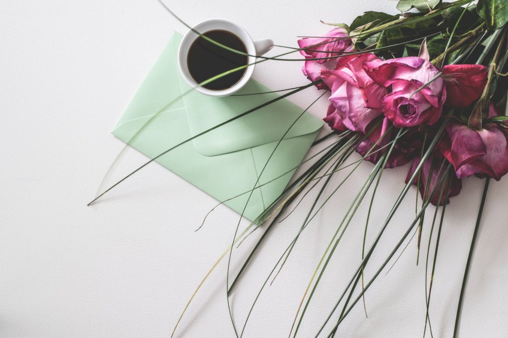 bouquet of pink flowers beside white ceramic mug